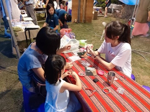 隨館員參加東海岸大地藝術節擺攤，製作薏米珠手串飾