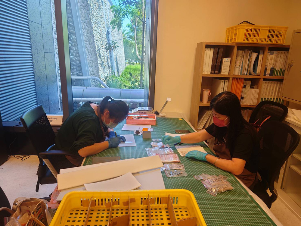 正在製作保存盒的志工冠榕與秀瓊。